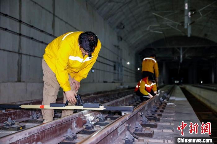 中國鐵路南寧局集團(tuán)有限公司南寧工務(wù)段職工使用道尺檢查吳圩機(jī)場高鐵站高鐵線路設(shè)備?！№f剛 攝